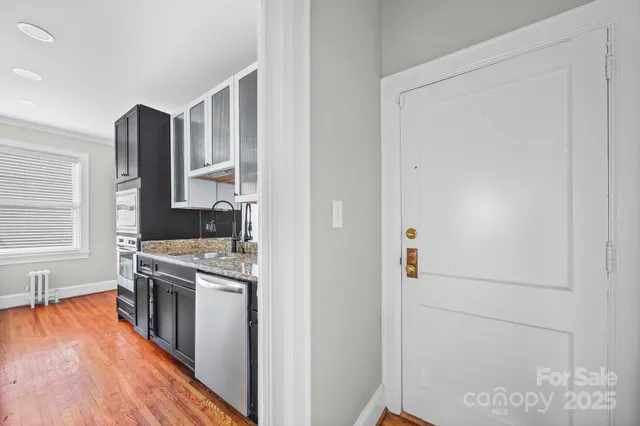 a kitchen with stainless steel appliances granite countertop a refrigerator a stove and a sink