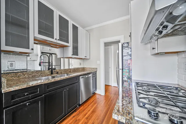 a kitchen with stainless steel appliances granite countertop a sink stove and cabinets