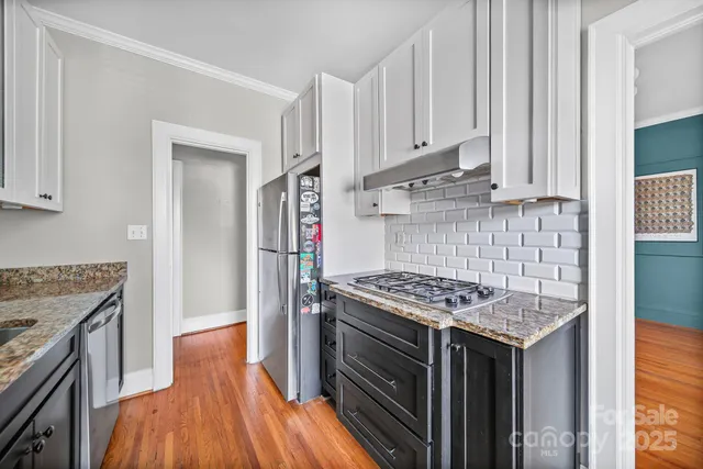 a kitchen with stainless steel appliances granite countertop a stove and a refrigerator