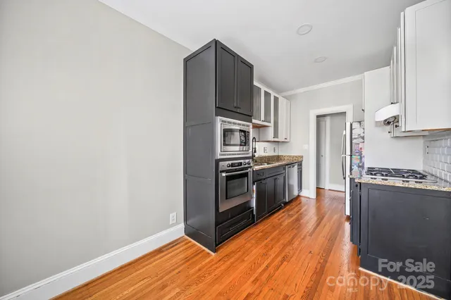 a kitchen with stainless steel appliances a refrigerator and a stove top oven
