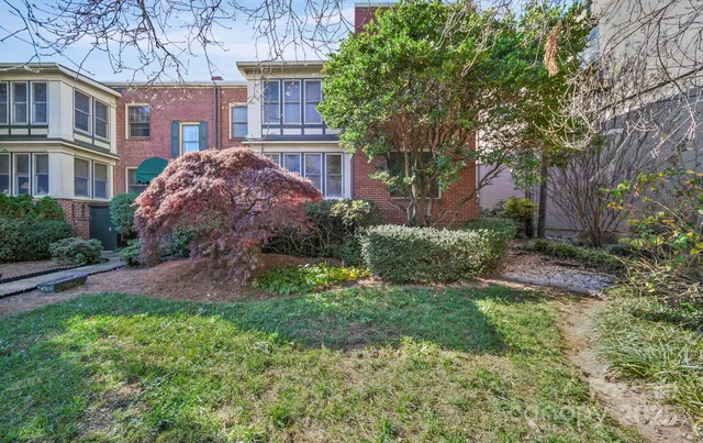 a front view of a house with a yard and shrubs