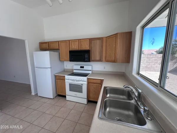 a kitchen with a sink a refrigerator and a stove top oven