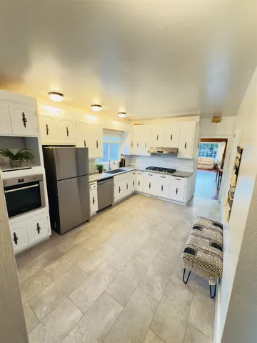 a kitchen with stainless steel appliances a stove a refrigerator and a stove