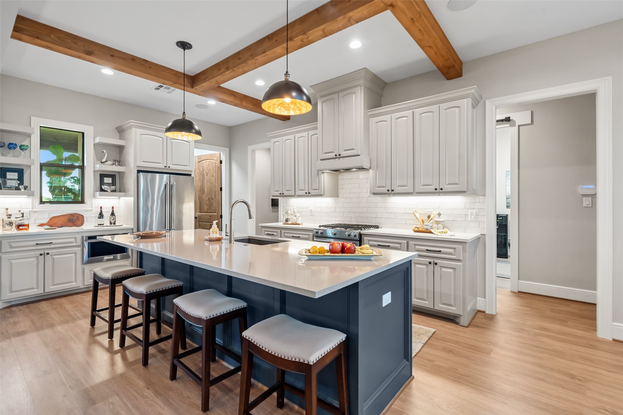 30163 High Spirit Ranch Road Hempstead, TX 77445 - Photo 13 of 47 With ceiling beams overhead and a
generous island with bar seating
below, the kitchen is built for hosting
and day-to-day ease.