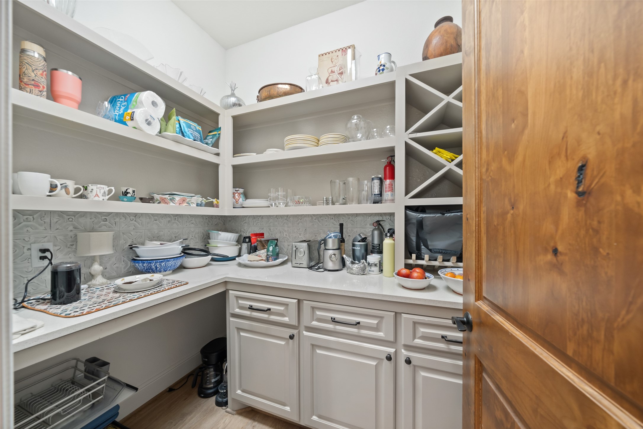 30163 High Spirit Ranch Road Hempstead, TX 77445 - Photo 15 of 47 Ample open shelving and cabinetry
provide practical storage in the walkin pantry, complete with a wine rack
and decorative backsplash.