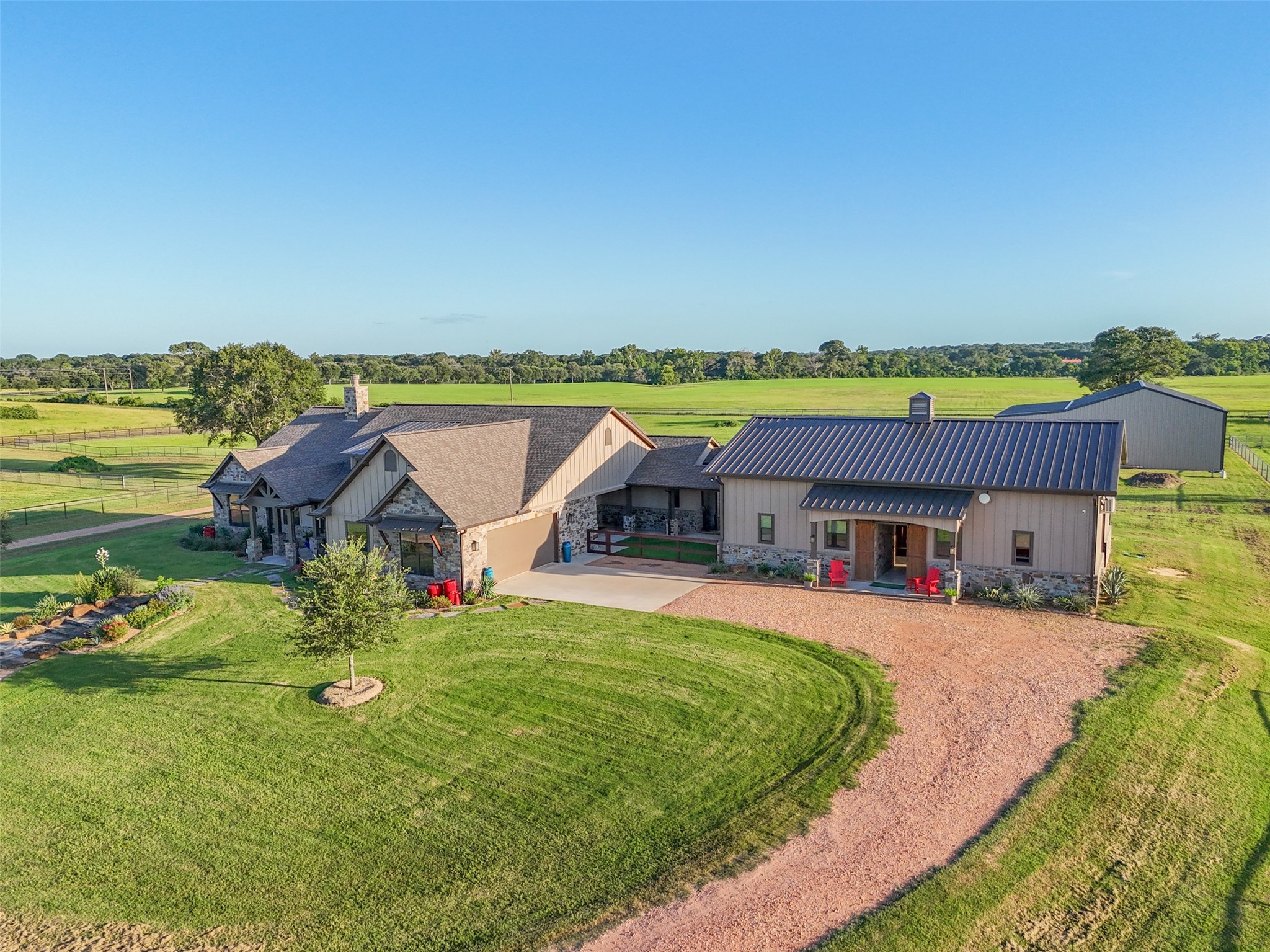 30163 High Spirit Ranch Road Hempstead, TX 77445 - Photo 2 of 47 Circular drive and extended parking
space connect the main house to the
adjacent barn and utility building with
covered porch.