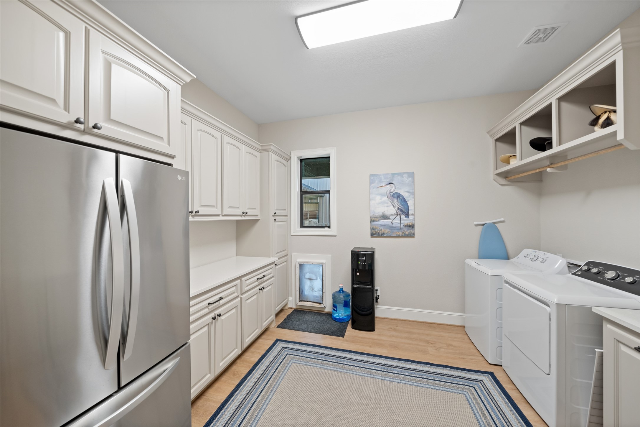 30163 High Spirit Ranch Road Hempstead, TX 77445 - Photo 30 of 47 The spacious laundry room includes
extensive cabinetry, folding counters,
washer/dryer connections, and even
a pet-friendly dog door for added
convenience. A second refrigerator
adds bonus utility