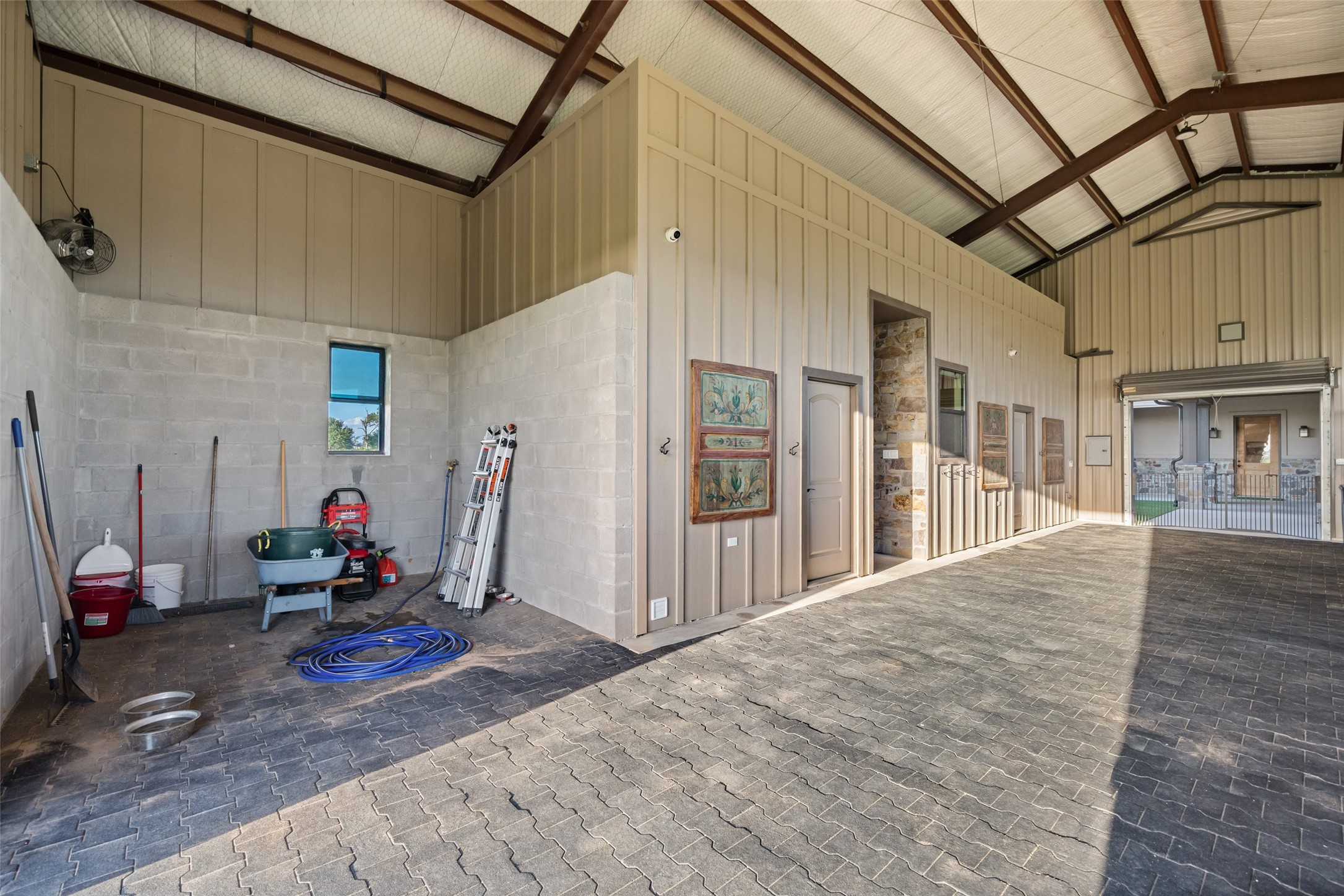 30163 High Spirit Ranch Road Hempstead, TX 77445 - Photo 38 of 47 This versatile barn interior features a
durable brick paver floor, tall ceilings
with exposed steel beams, a storage
room, tack space, and direct access
to the stalls and breezeway