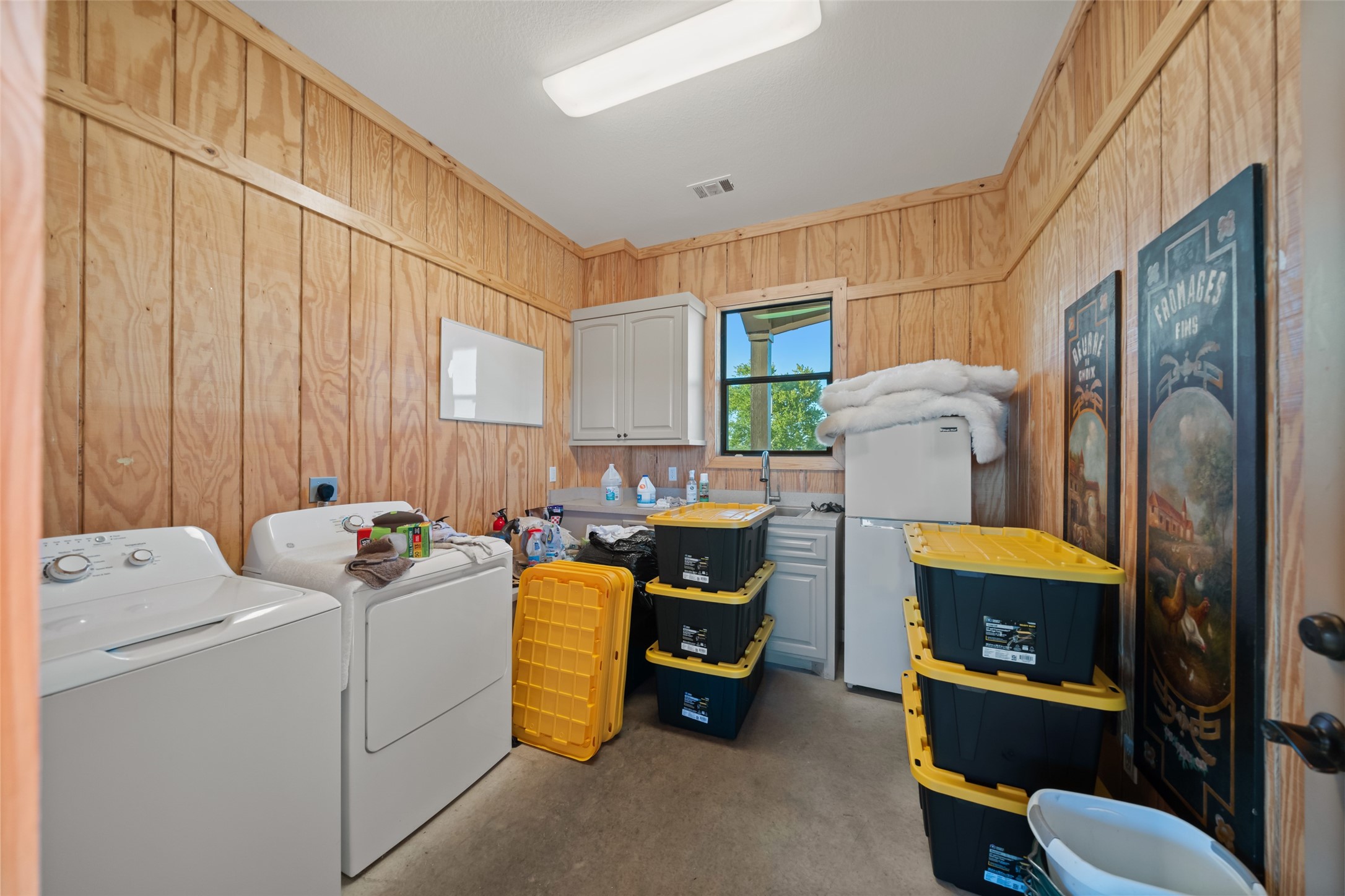 30163 High Spirit Ranch Road Hempstead, TX 77445 - Photo 43 of 47 The barn’s dedicated utility room
offers built-in cabinetry, a laundry
station, wash sink, and a secondary
refrigerator—perfect for managing
gear, cleaning, and daily tasks.