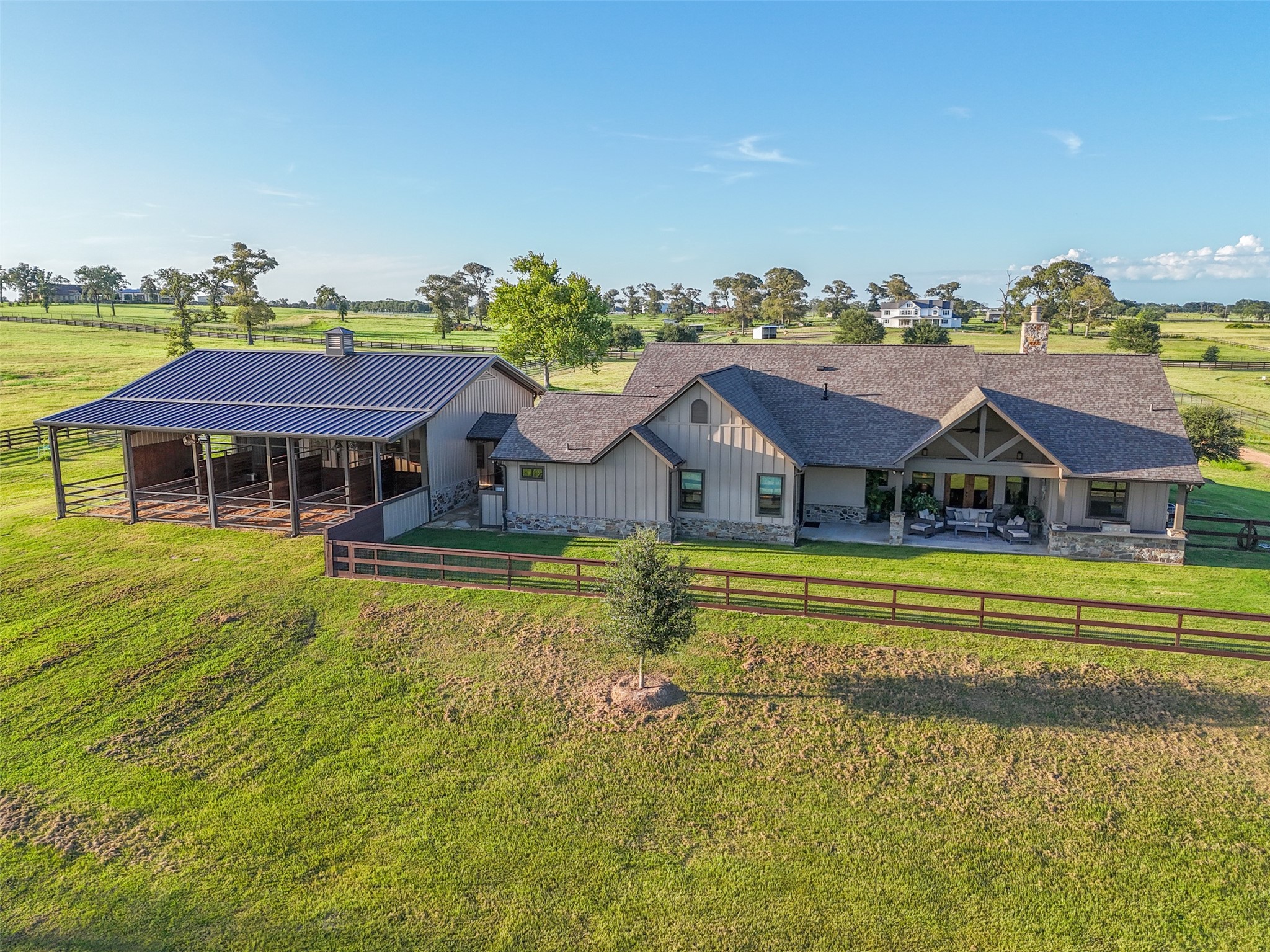 30163 High Spirit Ranch Road Hempstead, TX 77445 - Photo 44 of 47 This aerial view showcases the
thoughtful layout of the home, barn,
and covered patio, all set against the
backdrop of rolling fenced pastures.