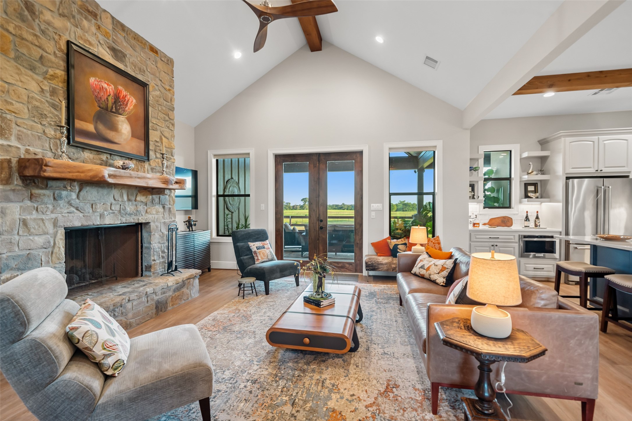 30163 High Spirit Ranch Road Hempstead, TX 77445 - Photo 7 of 47 Vaulted ceilings with exposed
beams, a statement stone fireplace,
and expansive windows create a
gathering space that’s both cozy and
open.