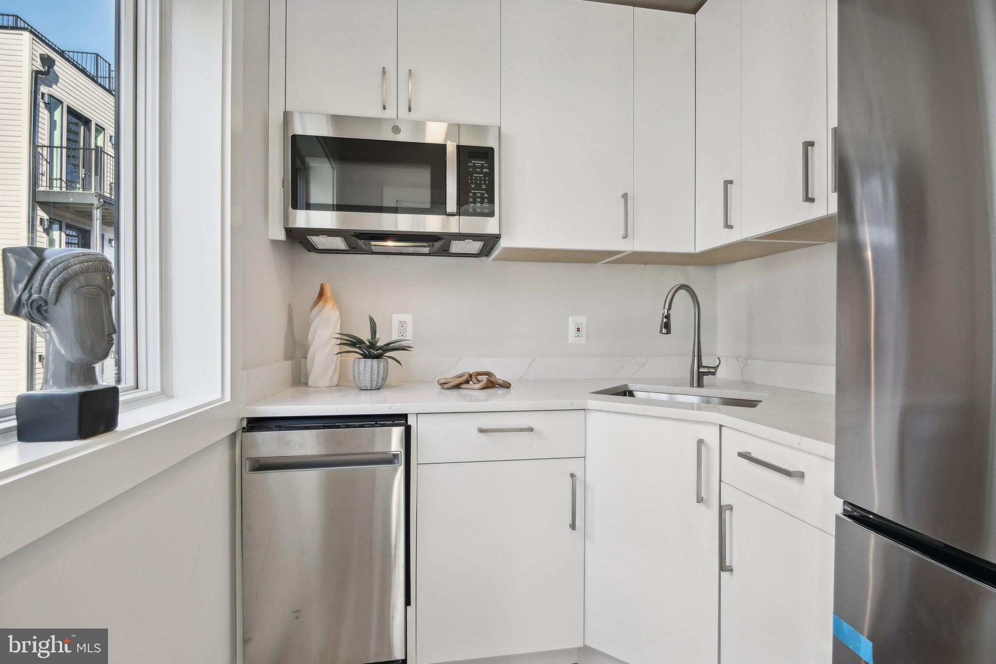 1748 Lanier Place Northwest, Unit 2 Washington, DC 20009 - Photo 24 of 33 a kitchen with stainless steel appliances granite countertop white cabinets a sink and dishwasher