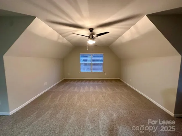 en empty room with windows and ceiling fan