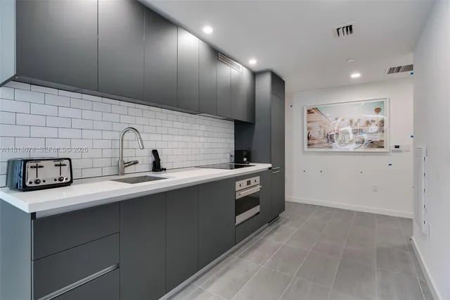 a kitchen with stainless steel appliances a sink a stove and cabinets