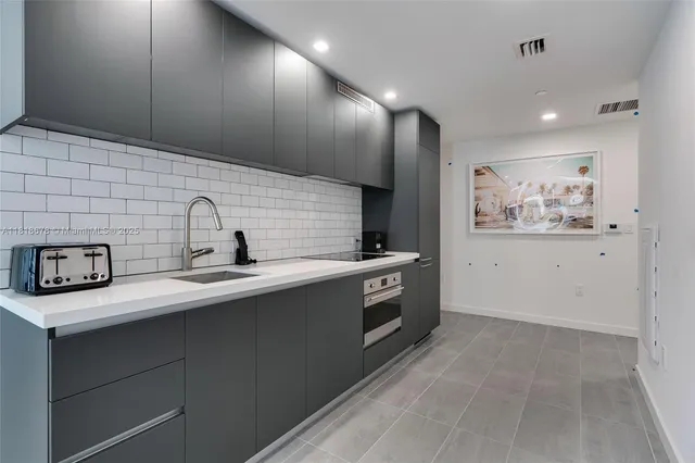 a kitchen with stainless steel appliances a sink a stove and cabinets