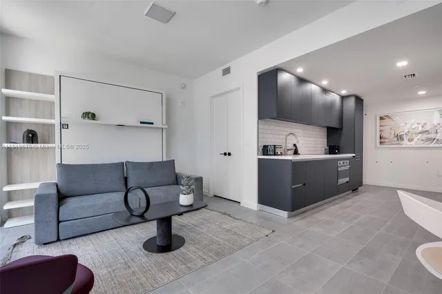 a living room with furniture and view of kitchen