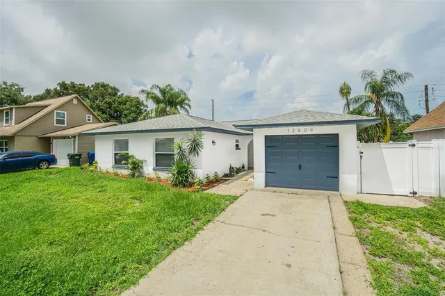 front view of a house with a yard and a garage