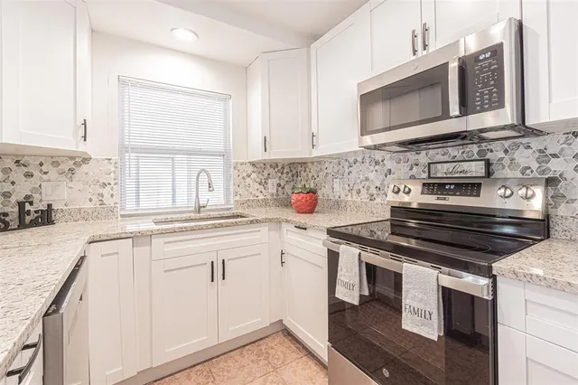 a kitchen with cabinets appliances and a sink