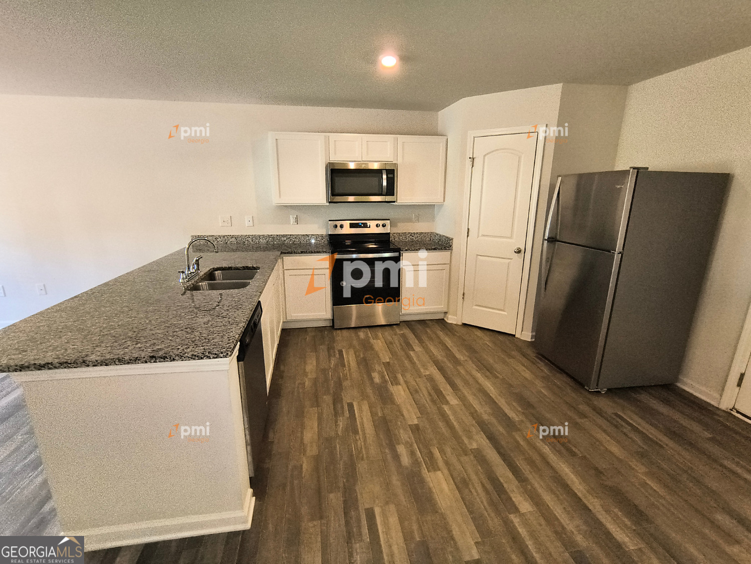 a kitchen with granite countertop a refrigerator stove and oven
