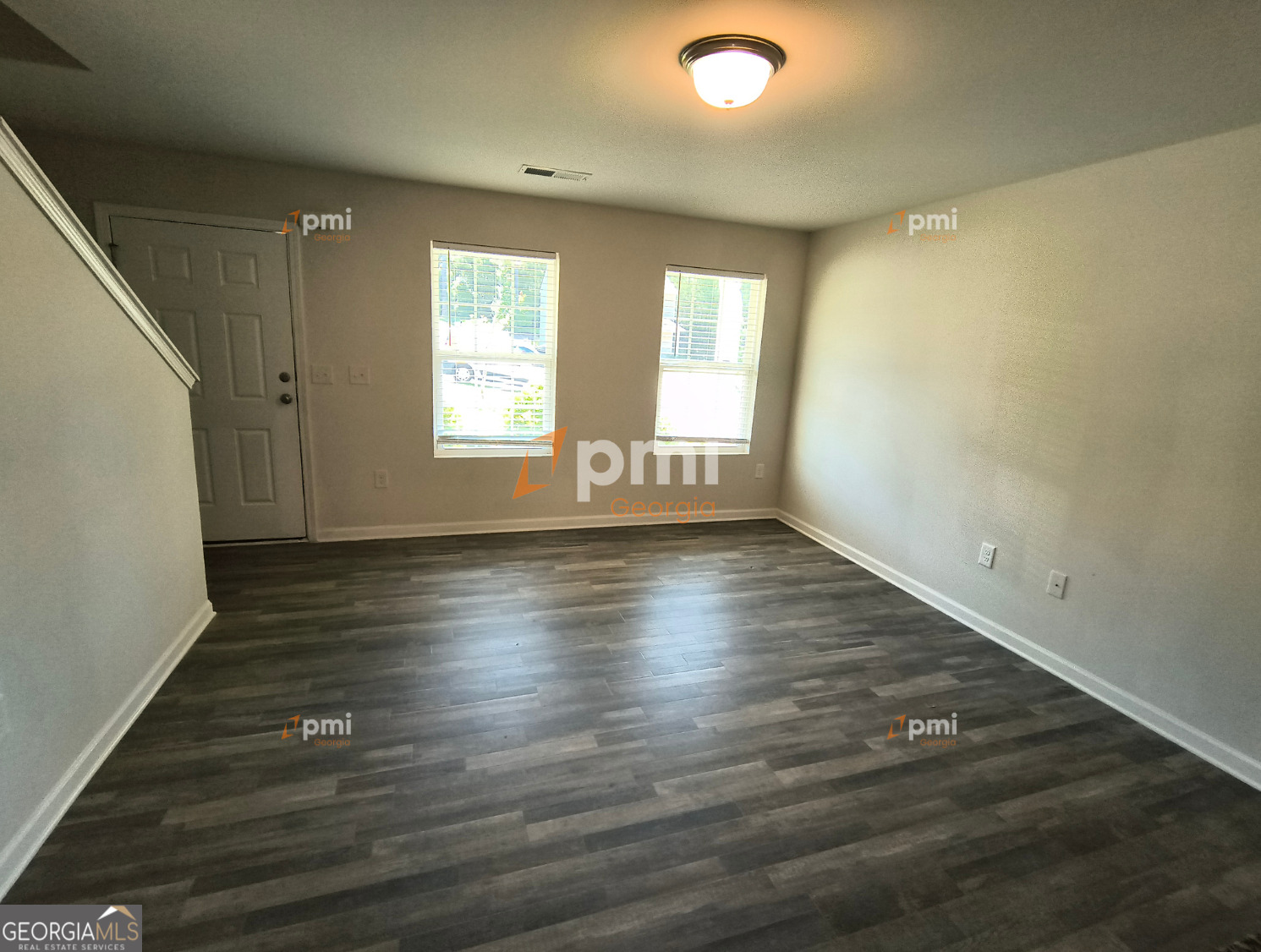 1552 Austin Drive Macon, GA 31217 - Photo 2 of 14 an empty room with wooden floor and windows with curtains