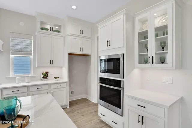 a kitchen with stainless steel appliances a cabinets and a window