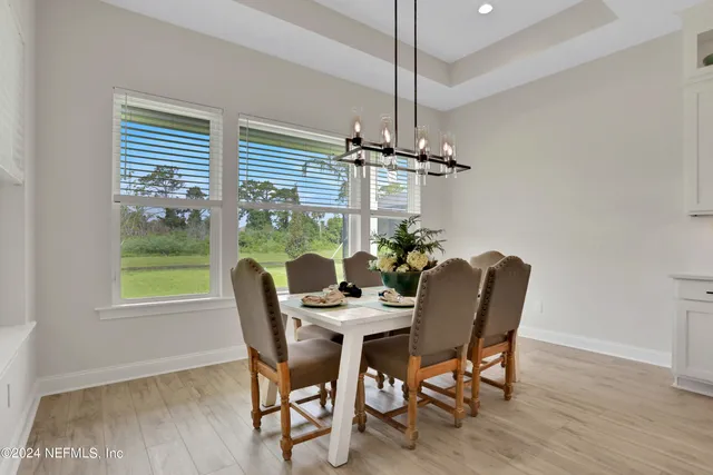 a dining room with furniture a chandelier and wooden floor