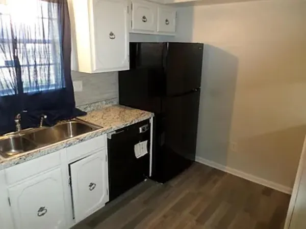 a kitchen with a refrigerator sink and cabinets
