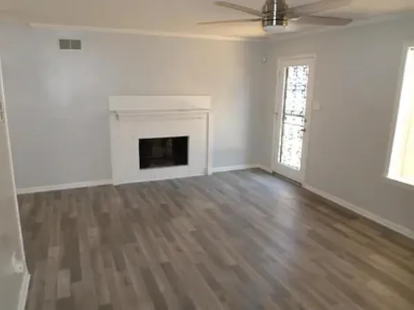 an empty room with windows and fireplace