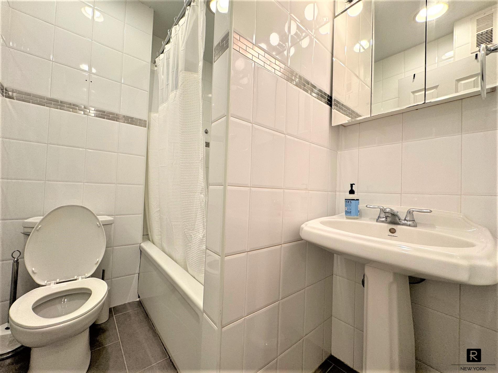 668 Riverside Drive, Unit 3H Manhattan, NY 10031 - Photo 5 of 5 a bathroom with a sink a toilet and a mirror