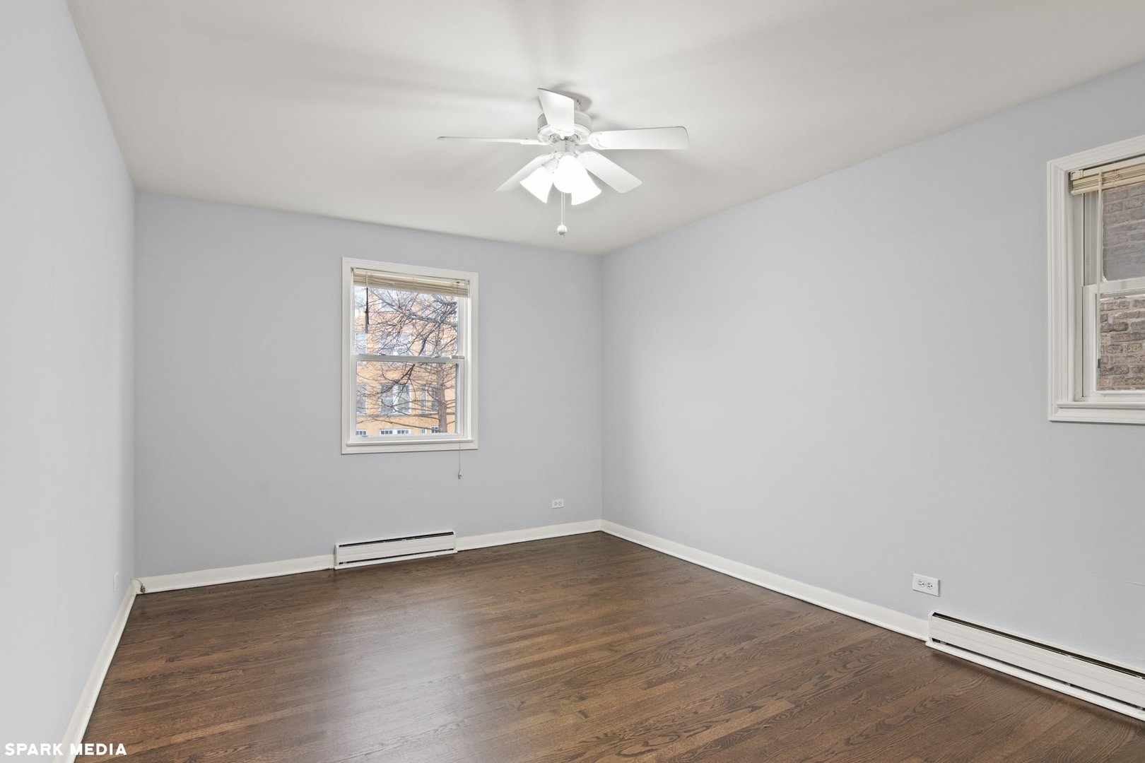 8847 La Crosse Avenue, Unit 204 Skokie, IL 60077 - Photo 11 of 16 an empty room with wooden floor chandelier fan and windows