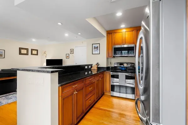 a kitchen with stainless steel appliances granite countertop a stove a sink and a refrigerator