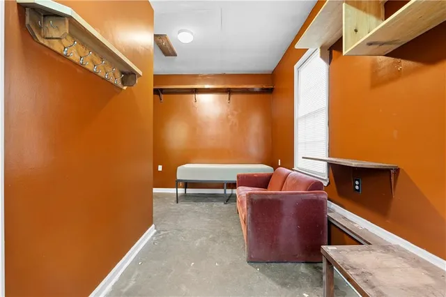 an empty room with chandelier fan and windows