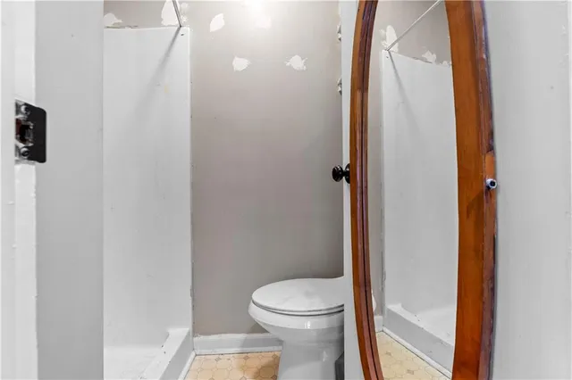 a bathroom with a toilet and a shower
