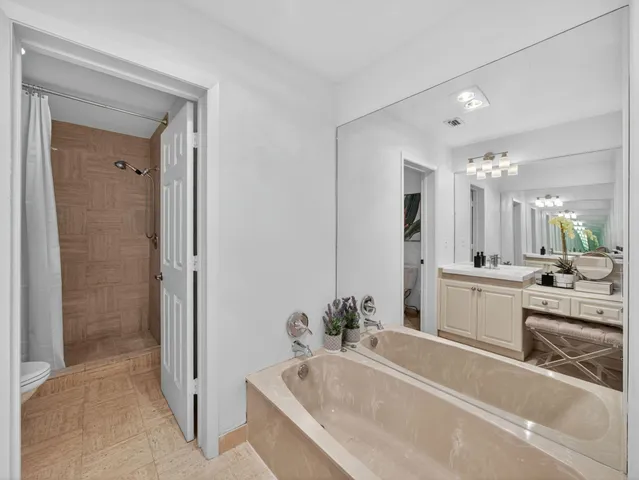 a large bathroom with a tub a sink and mirror