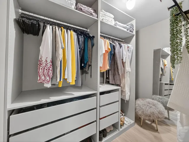 a view of walk in closet with clothes and shoes