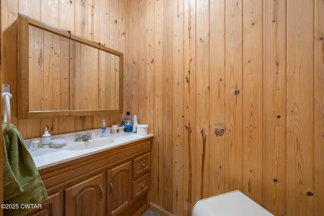 a view of a house with a small yard and a large tree