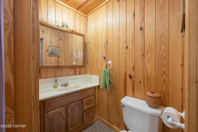 a living room with furniture two window and a flat screen tv