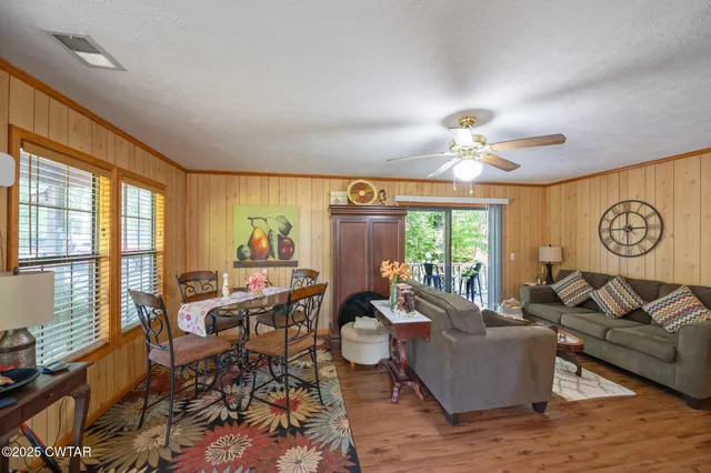 a living room with furniture a ceiling fan and a window
