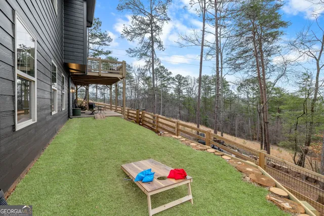 a view of a backyard with table and chairs potted plants and a large tree
