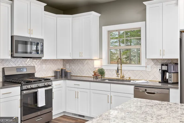 a kitchen with stainless steel appliances granite countertop a sink counter space and wooden floor