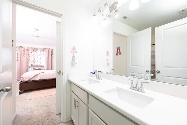 a en suite bathroom with a double vanity sink and a mirror
