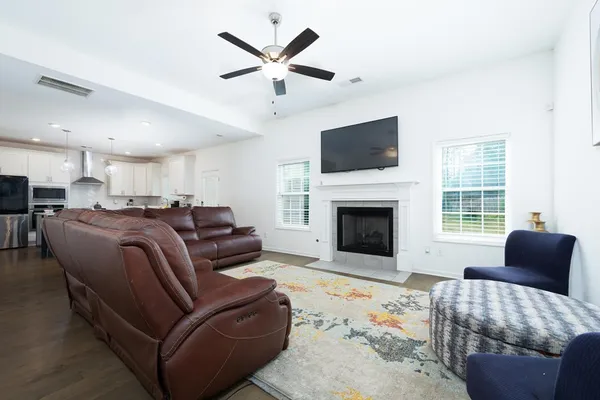 a living room with furniture a flat screen tv and a fireplace