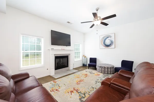 a living room with furniture a flat screen tv and a fireplace