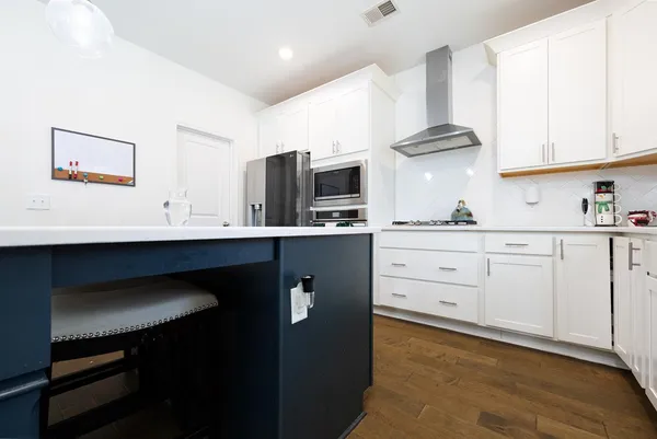 a kitchen with cabinets stainless steel appliances a sink and a window