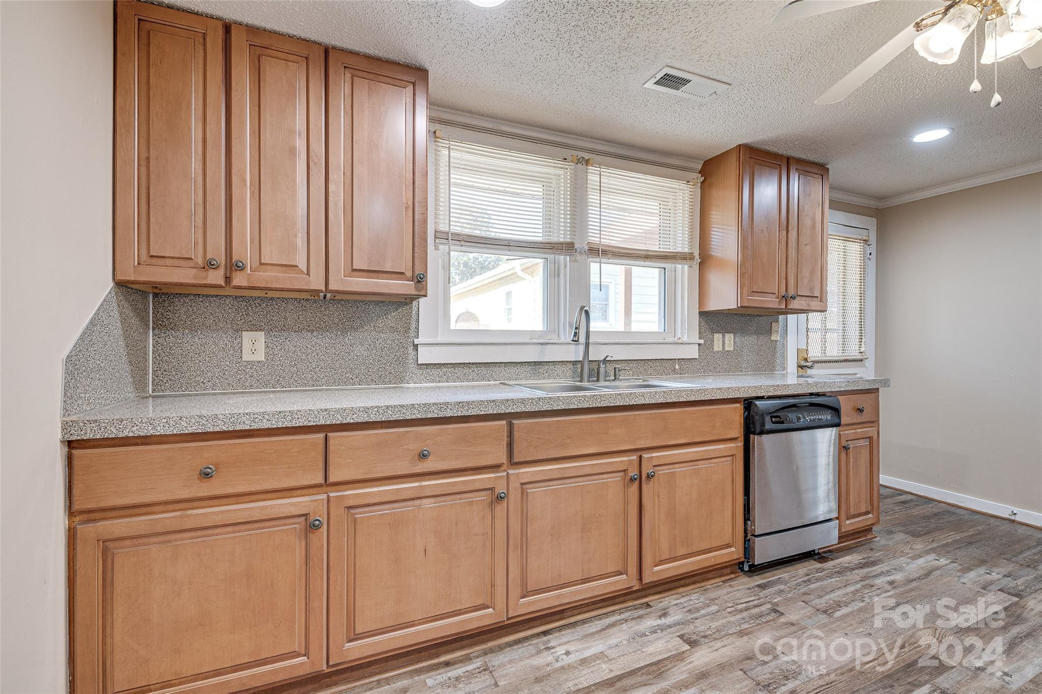 a kitchen with granite countertop stainless steel appliances sink and cabinets