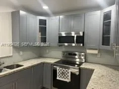 a kitchen with stainless steel appliances granite countertop a sink and a stove