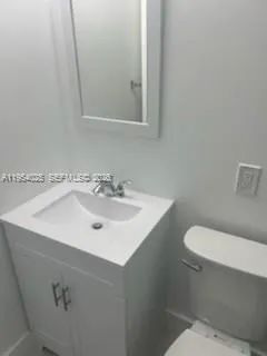 a bathroom with a sink a toilet and mirror