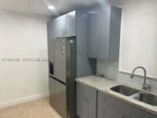 a kitchen with a refrigerator and a sink