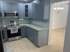 1680 Northeast 5th Street Homestead, FL 33033 - Photo 4 of 26 a kitchen with stainless steel appliances granite countertop a stove a microwave and cabinets