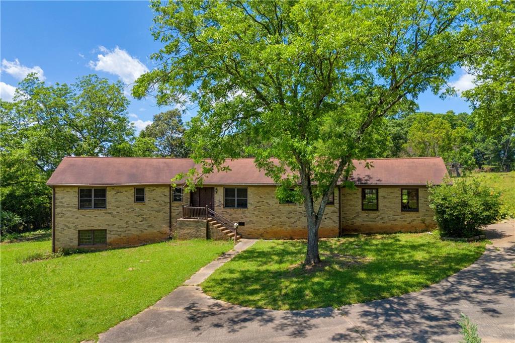 2505 Commerce Road Athens, GA 30607 - Photo 1 of 1 a front view of a house with a garden and trees